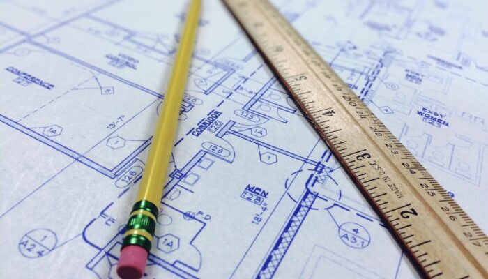 Projektová dokumentace pro stavbu garáže s výkresem a měřicími pomůckami před vyřízením potřebných povolení.