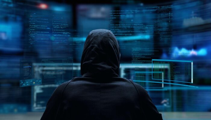 Bankovní podvod - hacker provádějící kybernetický útok s cílem získat přístup k bankovnímu účtu.